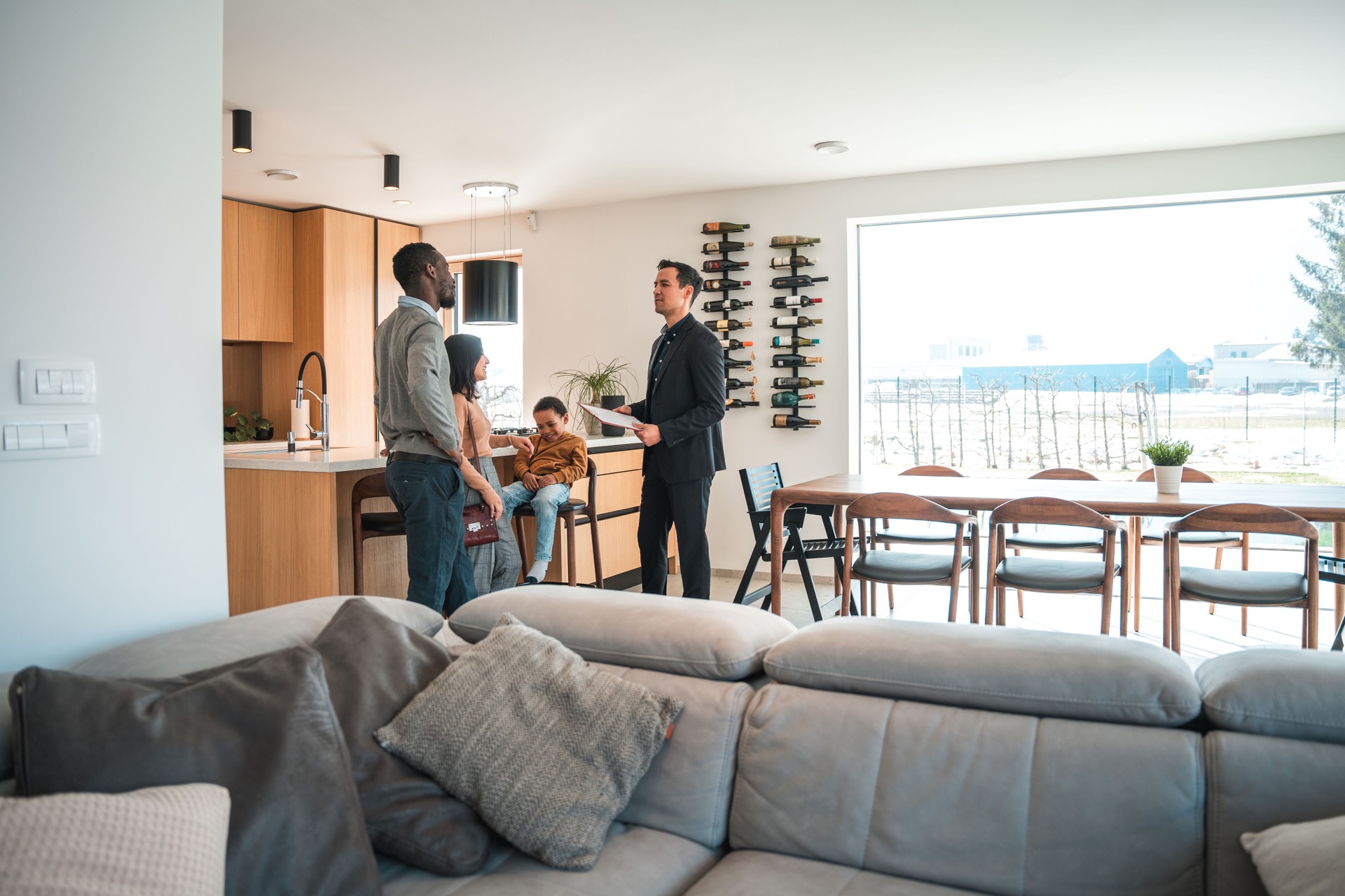 Asian Real Estate Agent Giving A Diverse Family A House Tour